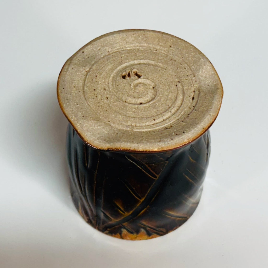 Handmade tenmoku cup with carved geometric pattern and amber glazed rim, artisan ceramic North Carolina pottery.