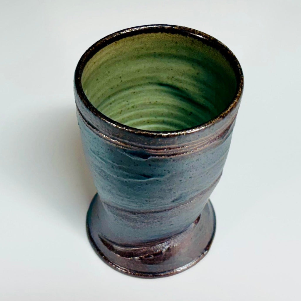 Handcrafted wood-fired pottery cup with green-dark brown exterior and celadon green interior, made in Danbury, NC.