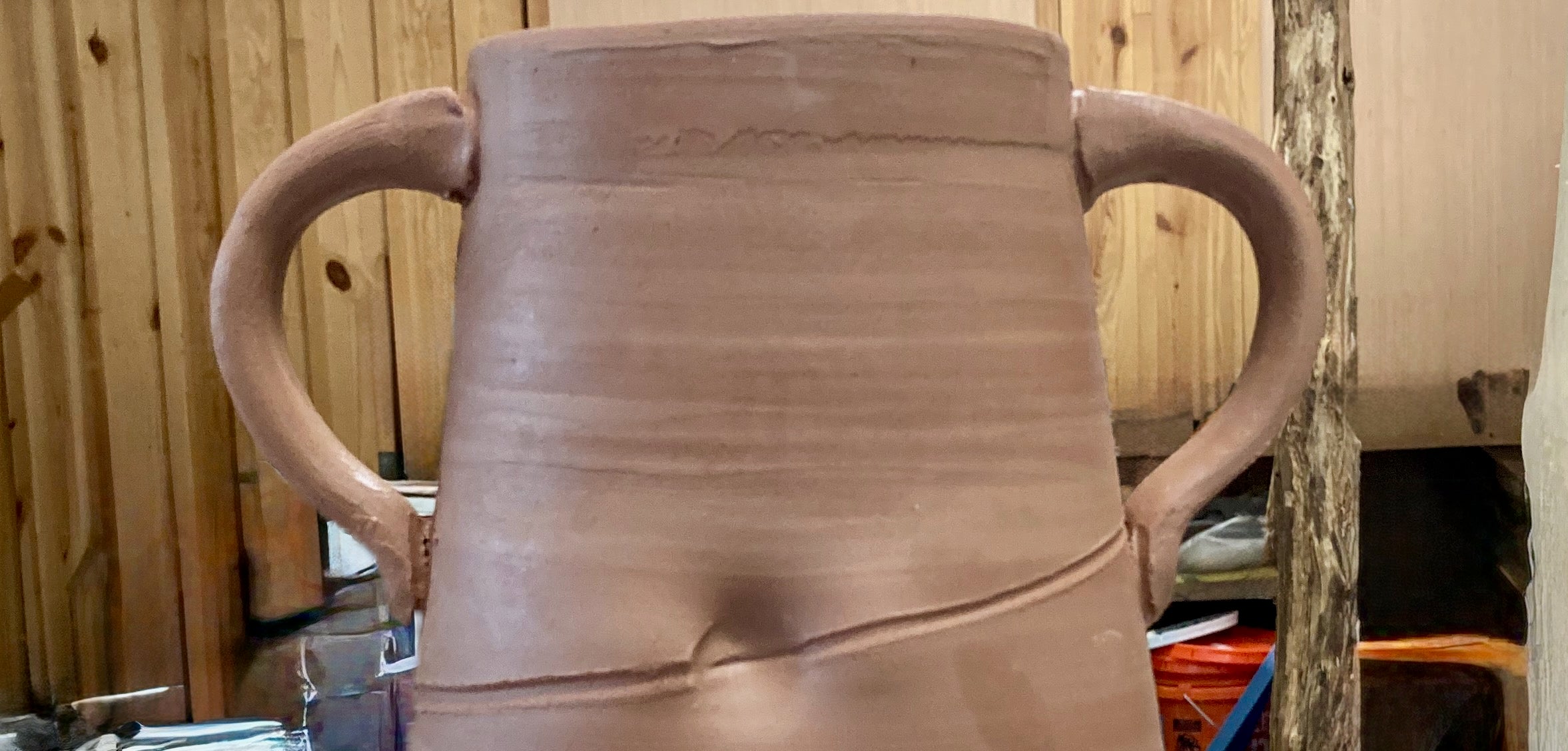 Before image of an unfinished jug in the studio awaiting firing as compared to the after photo of the finished jug.