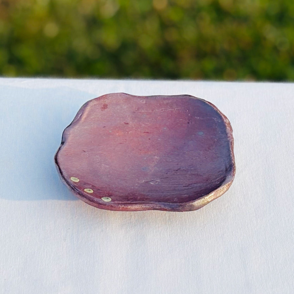 Unglazed wood-fired ceramic soap dish with natural slip trailed green glaze and green dots on a raised edge