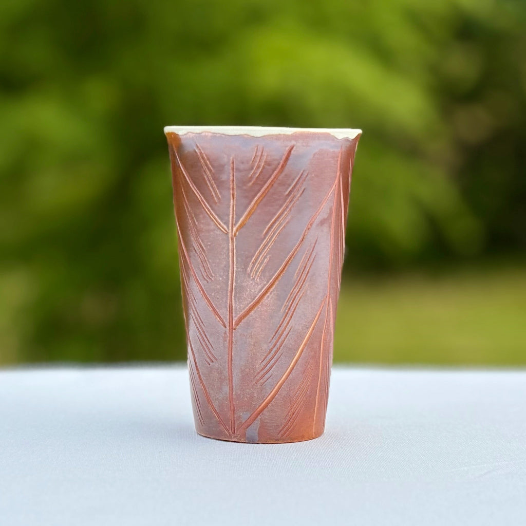 Porcelain cup made in Danbury, NC featuring a rich red/brown metallic sheen and incised decorating lines