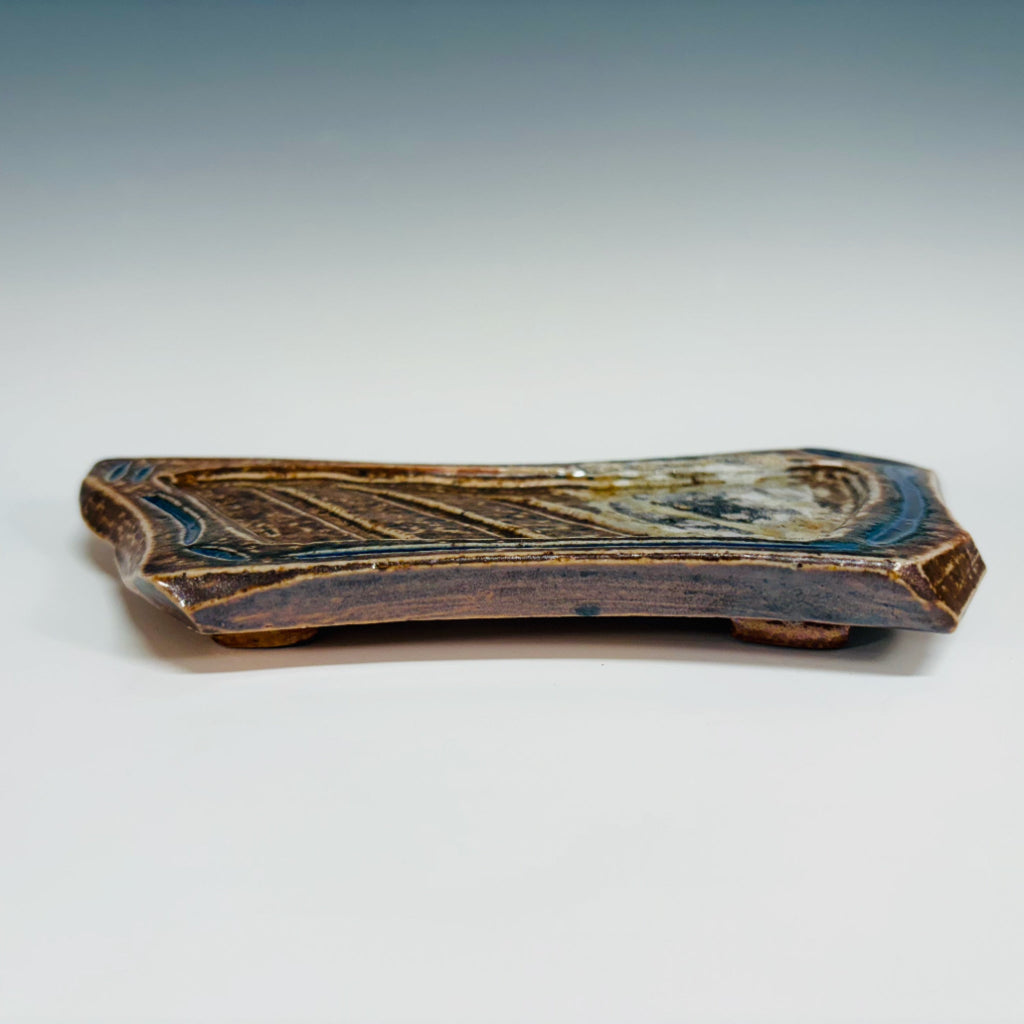 Handcrafted elongated soap dish with carved pattern and vibrant blue accents on brown stoneware, wood-fired in Danbury, NC.