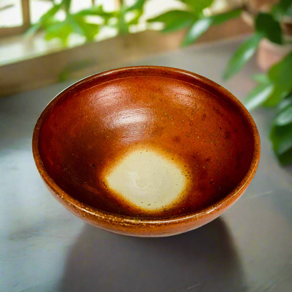 Interior view of handmade copper glaze pottery bowl showing unique wood-firing effects and natural color variation
