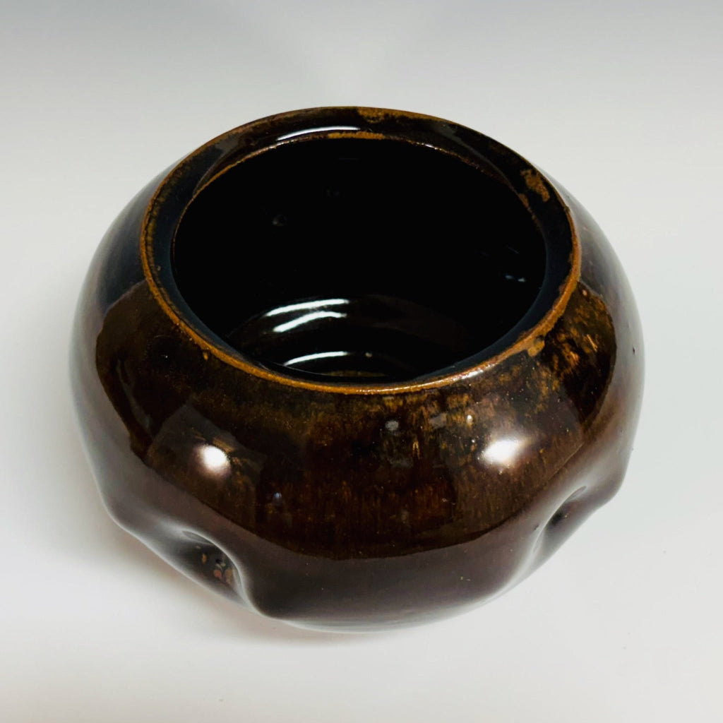 Top view: Round chestnut glazed vase with tactile dimpled surface, handmade and wood-fired in Danbury, NC.