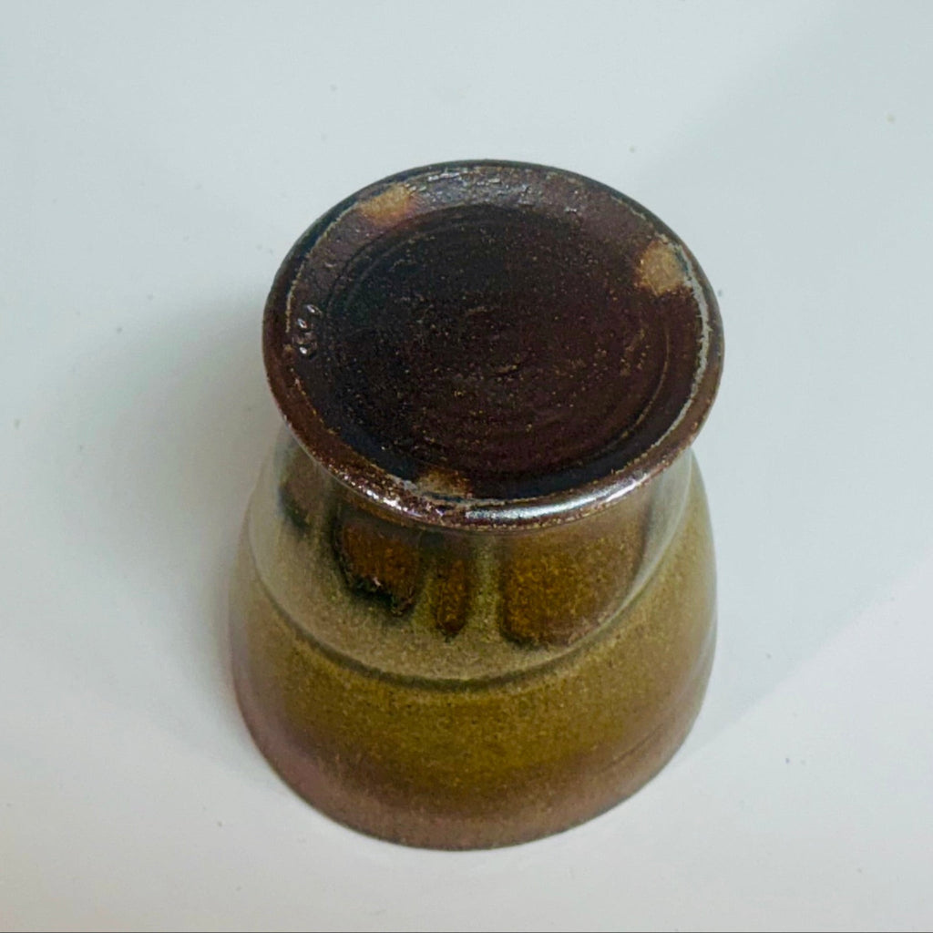 Handcrafted wood-fired ceramic tumbler with delicate greenish brown to chocolate transitions and horizontal banding.