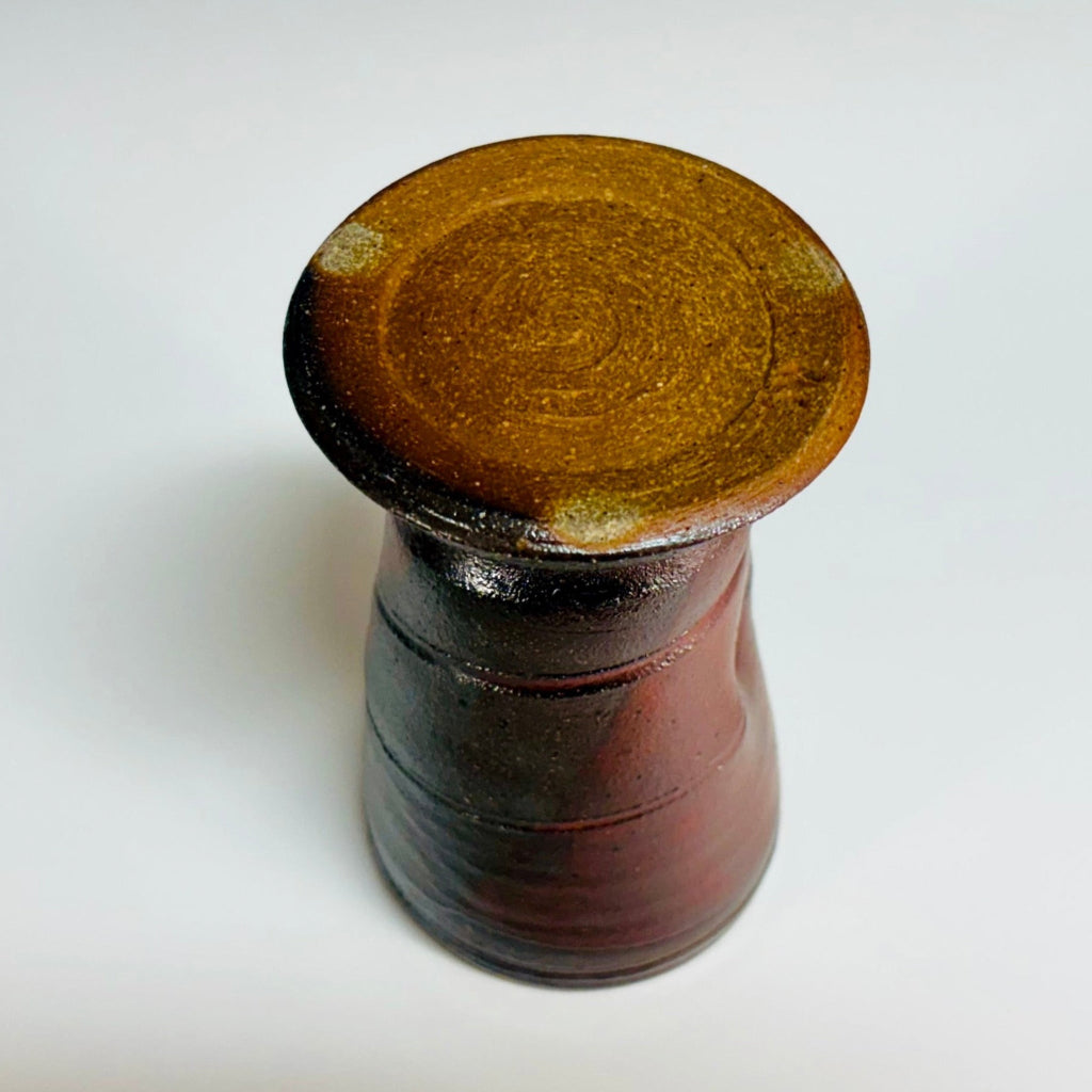 handcrafted wood-fired stoneware tumbler with natural clay bottom horizontal ridges and rich mahogany color