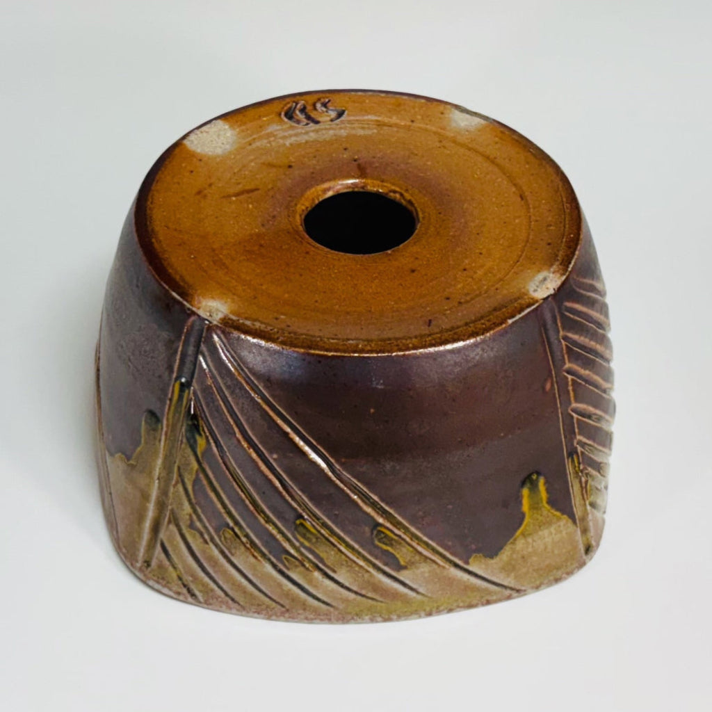 Bottom view of square ceramic planter showing exterior brown glaze and drainage hole.