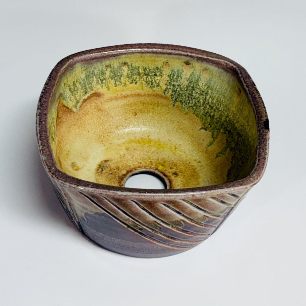  Top view of hand-carved square ceramic planter showing golden-brown rim and diagonal texture pattern.