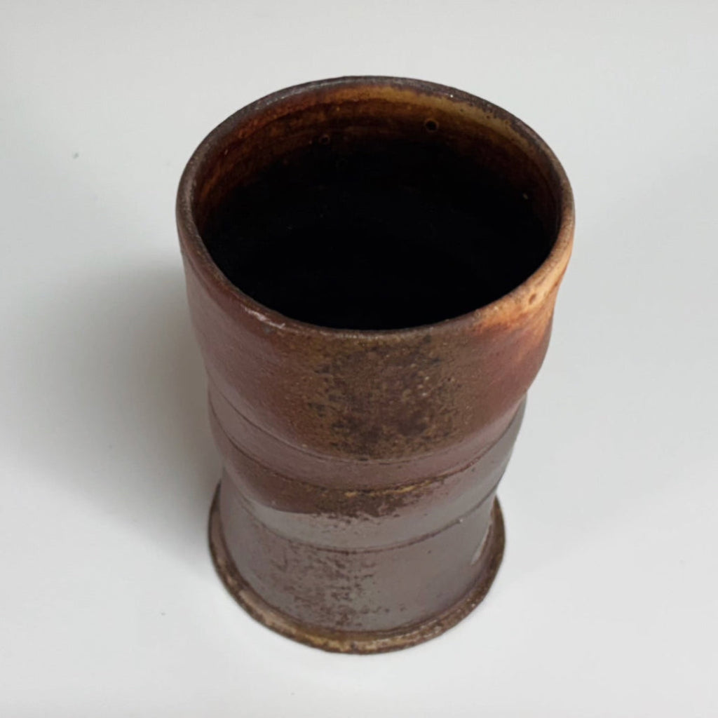 Hand-thrown copper-banded tenmoku cup with distinctive ridges, wood-fired in historic NC kiln.