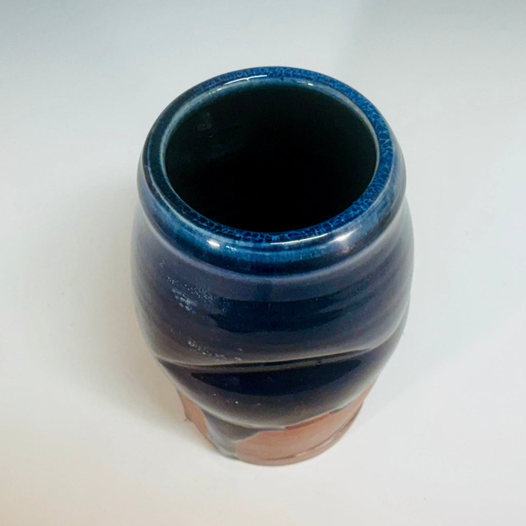 Side view but showing some of the blue interior: Artisan medium vase with deep blue glaze flowing over flashing slip, handmade and wood-fired in Danbury, NC.