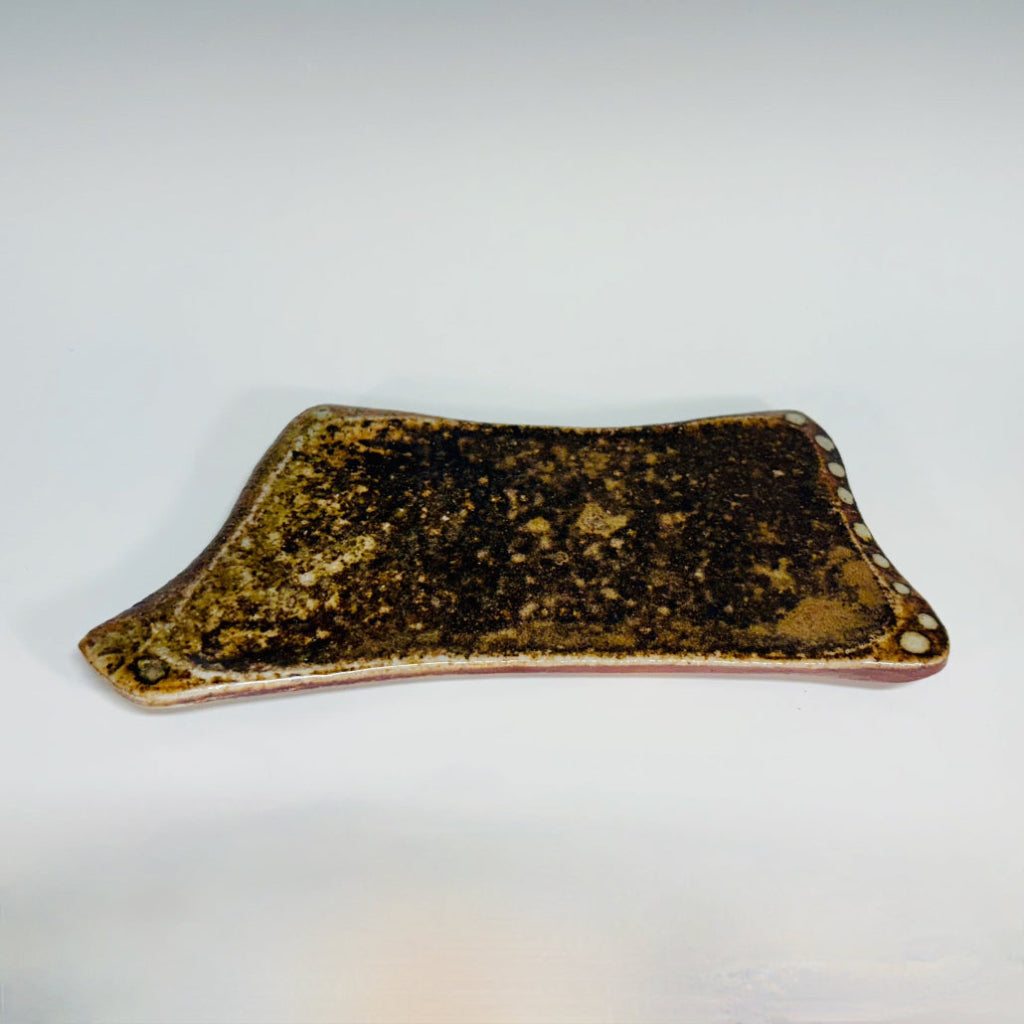 Handmade earth-tone stoneware soap dish with natural speckled texture and slightly raised edges. 