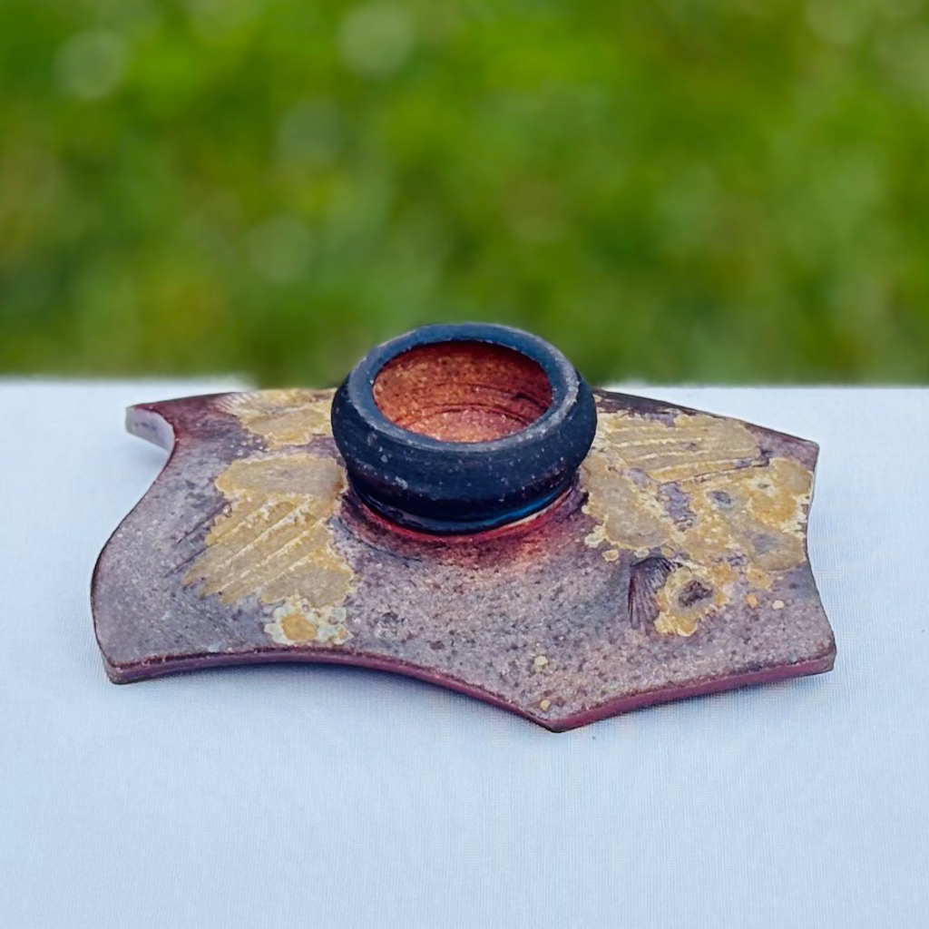 Underside of wood-fired soap dish showing ceramic construction and artisan potter signature