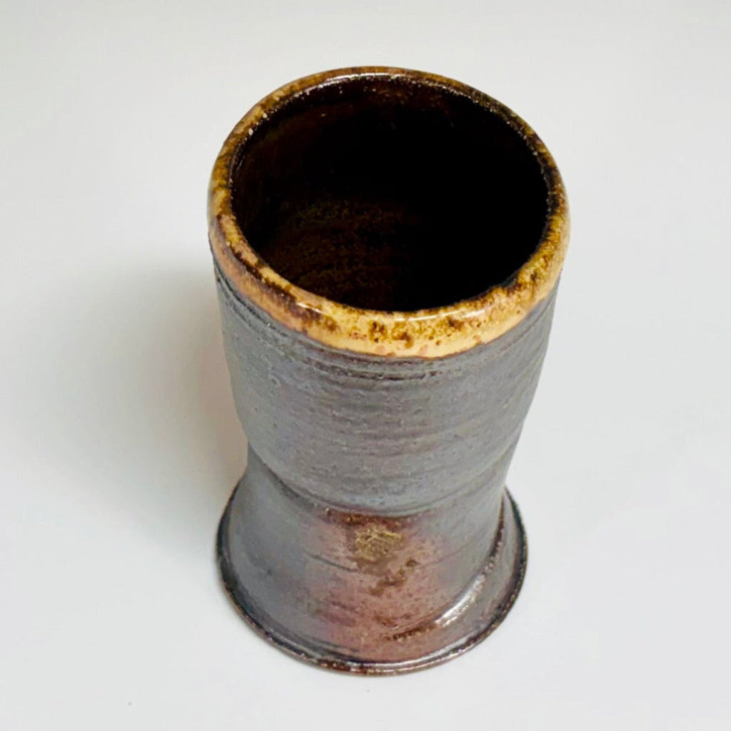 Top view of handcrafted wood-fired ceramic tumbler with charcoal exterior, dark brown interior, and golden-brown glazed rim, made in Danbury, NC.