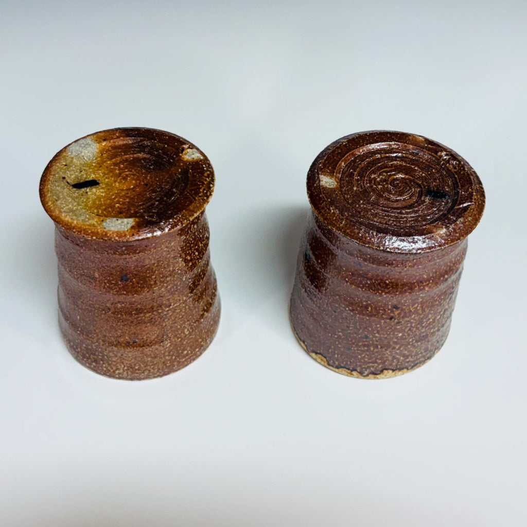 Pair of handcrafted wood-fired ceramic tumblers with sandy textured exterior and warm golden interior glaze