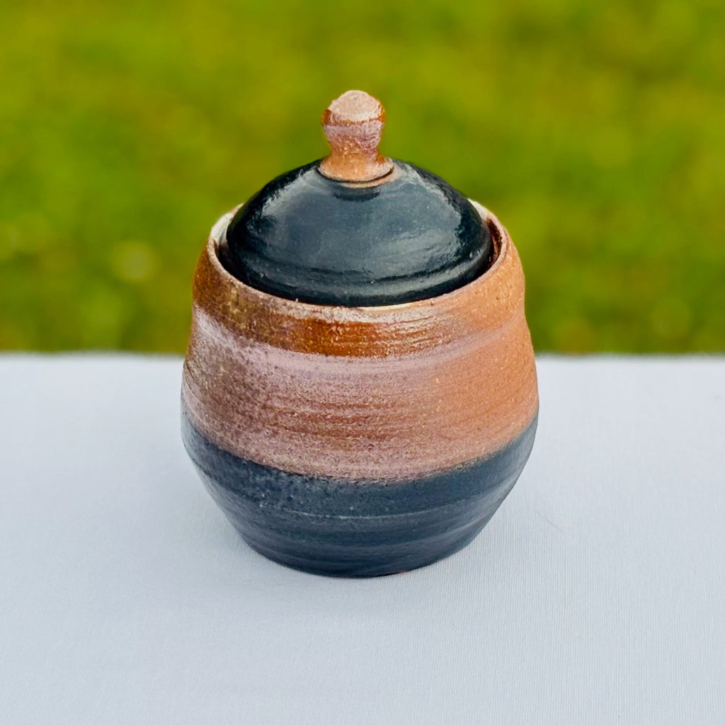 Artisan storage jar showing contrast between glazed peacock slip and unglazed stoneware