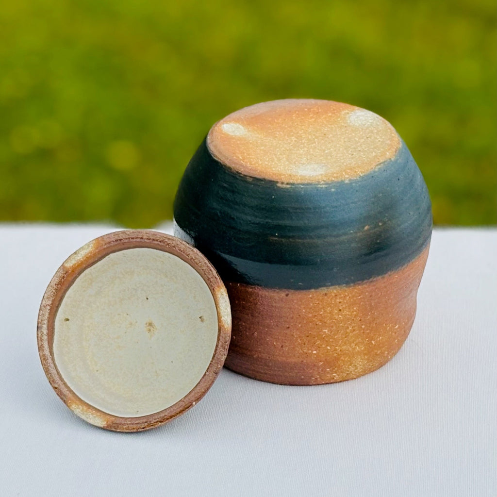 Bottom view of handcrafted ceramic jar showing natural stoneware foot and blue slip detail