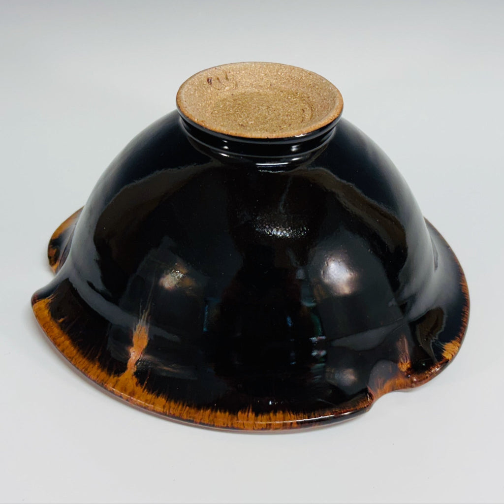 Dark brown/black pottery bowl with high shine glaze and a amber rims and a sturdy base with SD signature