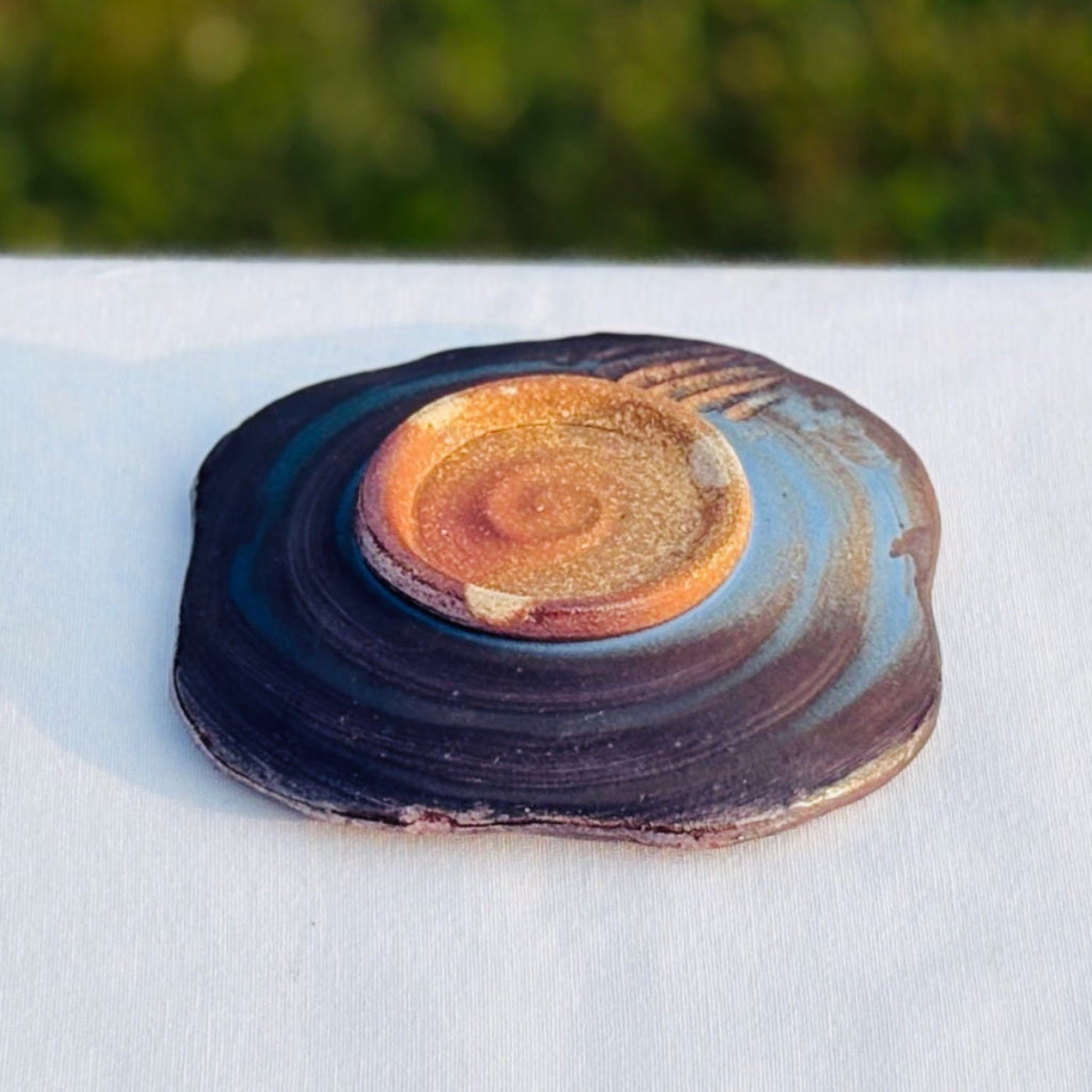 wood-fired pottery soap dish with a natural clay foot and circular pattern and carved marks