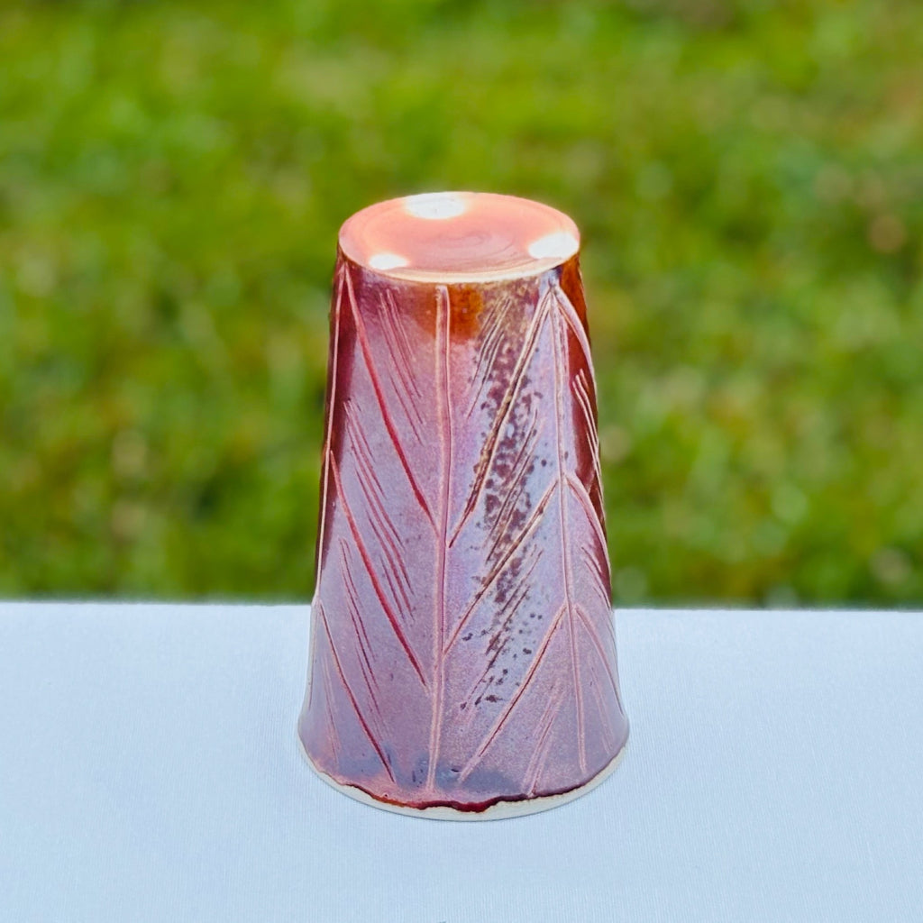 Carved porcelain cup with an unglazed bottom with three white "wadding" marks from where the cup made contact with the shelf during firing. 