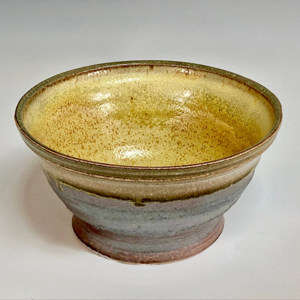 Inside view of handcrafted ceramic planter showing yellow-cream interior and drainage hole.
