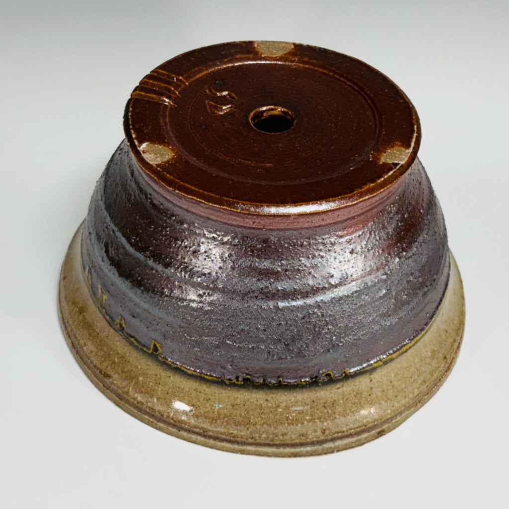 Bottom view of dual-tone ceramic planter showing drainage hole and glazed base.