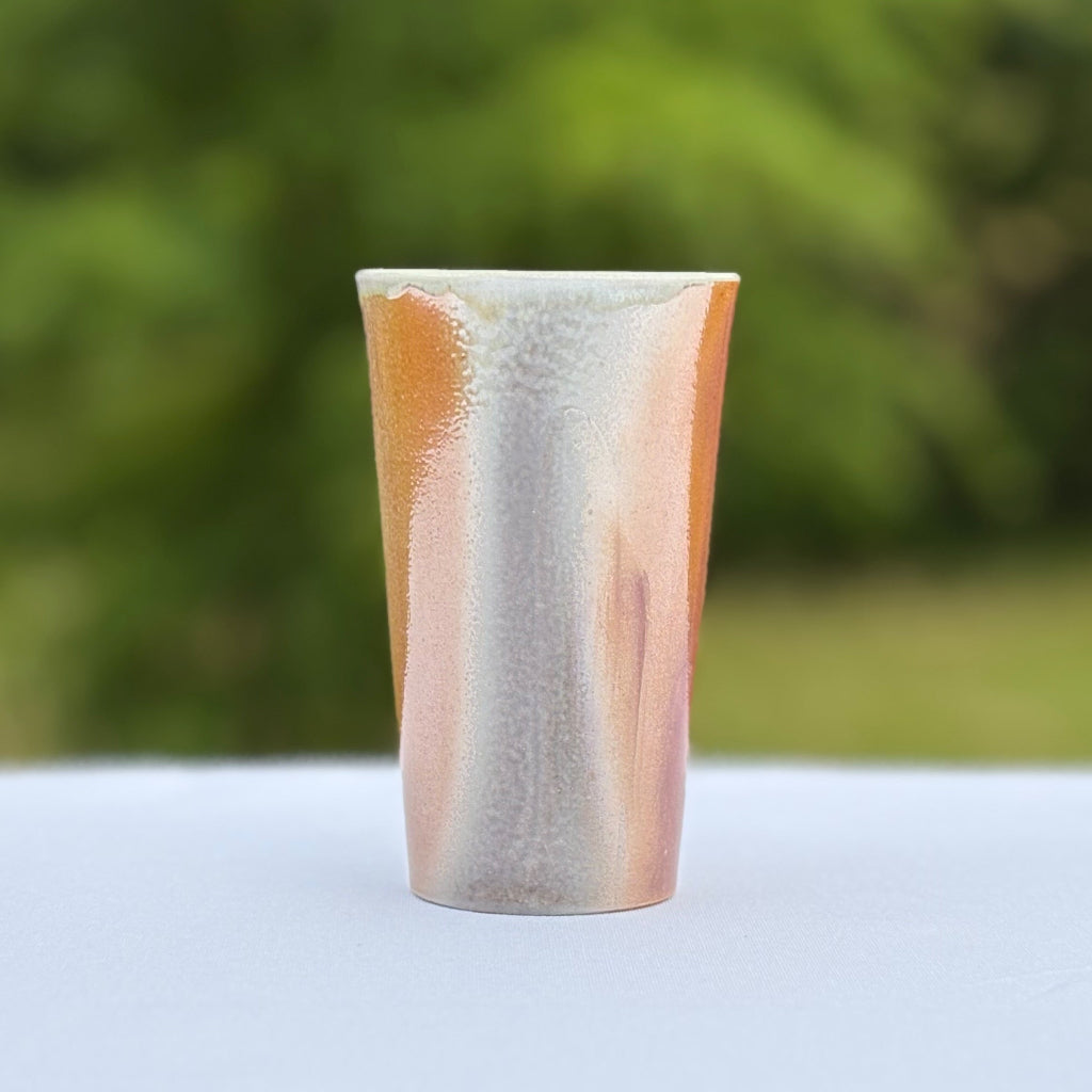 Wood-fired porcelain cup by Sam Dougherty with soft gray blush and pink/peach gradient finish, unglazed exterior, and white interior glaze