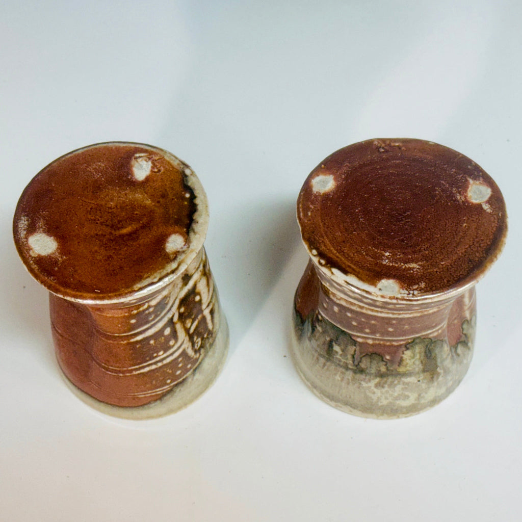Pair of handcrafted wood-fired ceramic tumblers with amber bottoms and three cream dots