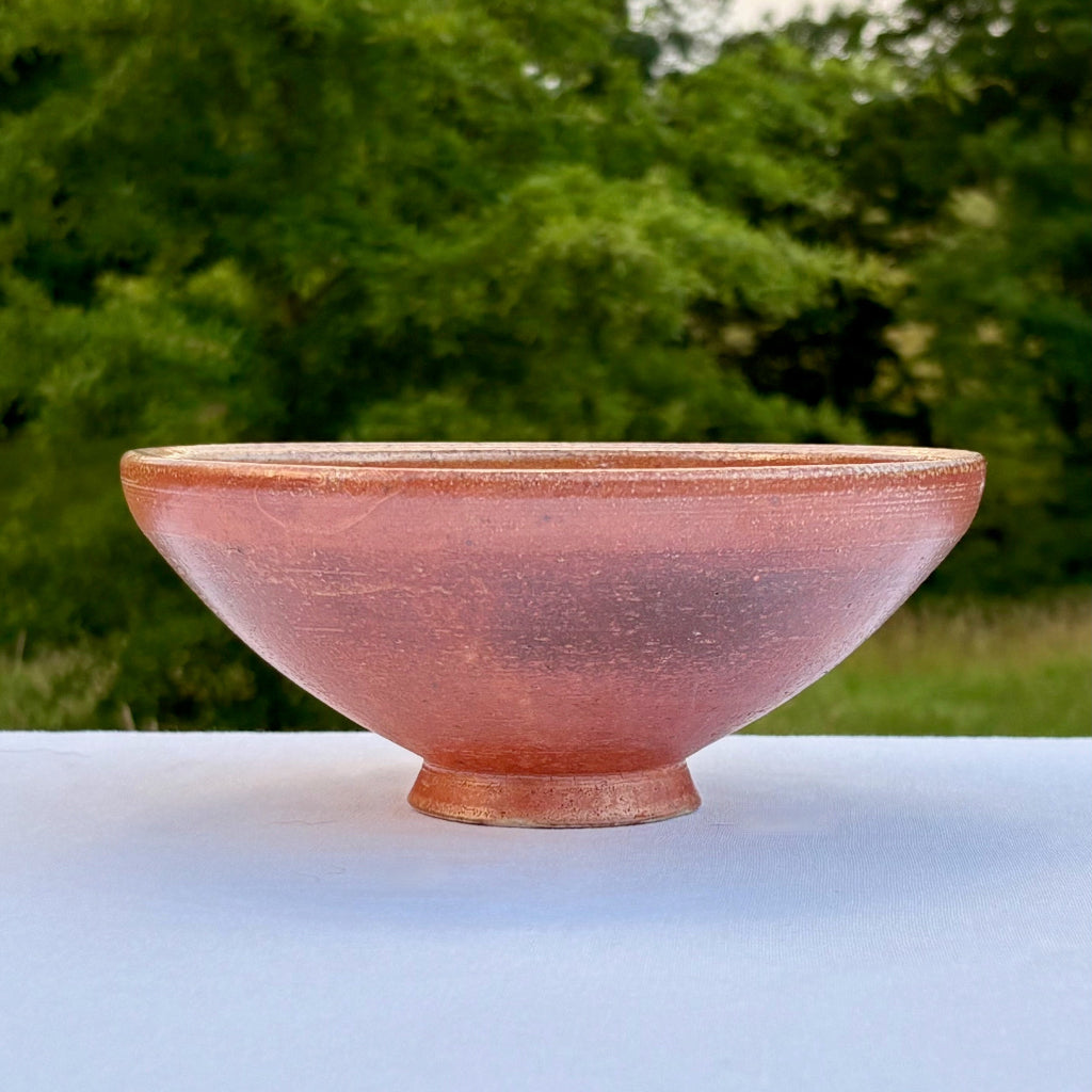 Wood-fired ceramic bowl showing glossy shino interior and textured orange exterior. Made in Stokes County, NC