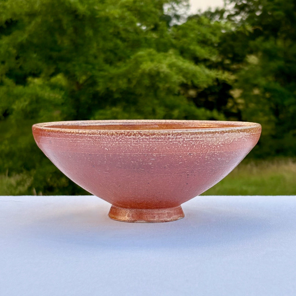 Handmade orange shino ceramic bowl with matte wood-fired exterior finish
