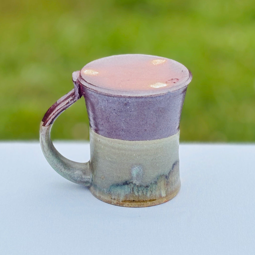 Oribe Ceramic mug with an unglazed dark earthly brown bottom, earthy lower half and a variegated green upper half. handmade in Danbury, NC.