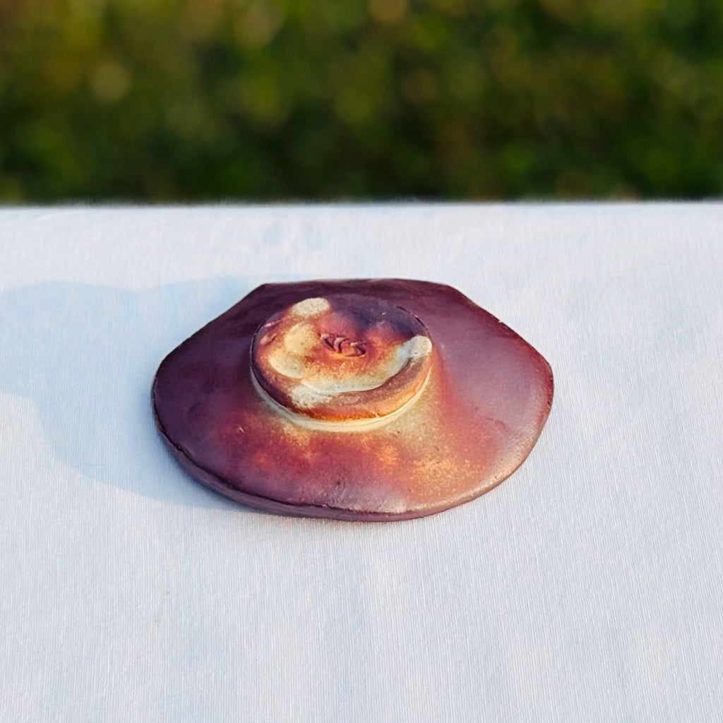 Bottom view of shell-shaped soap dish showing potter's mark and wood-fired ceramic construction