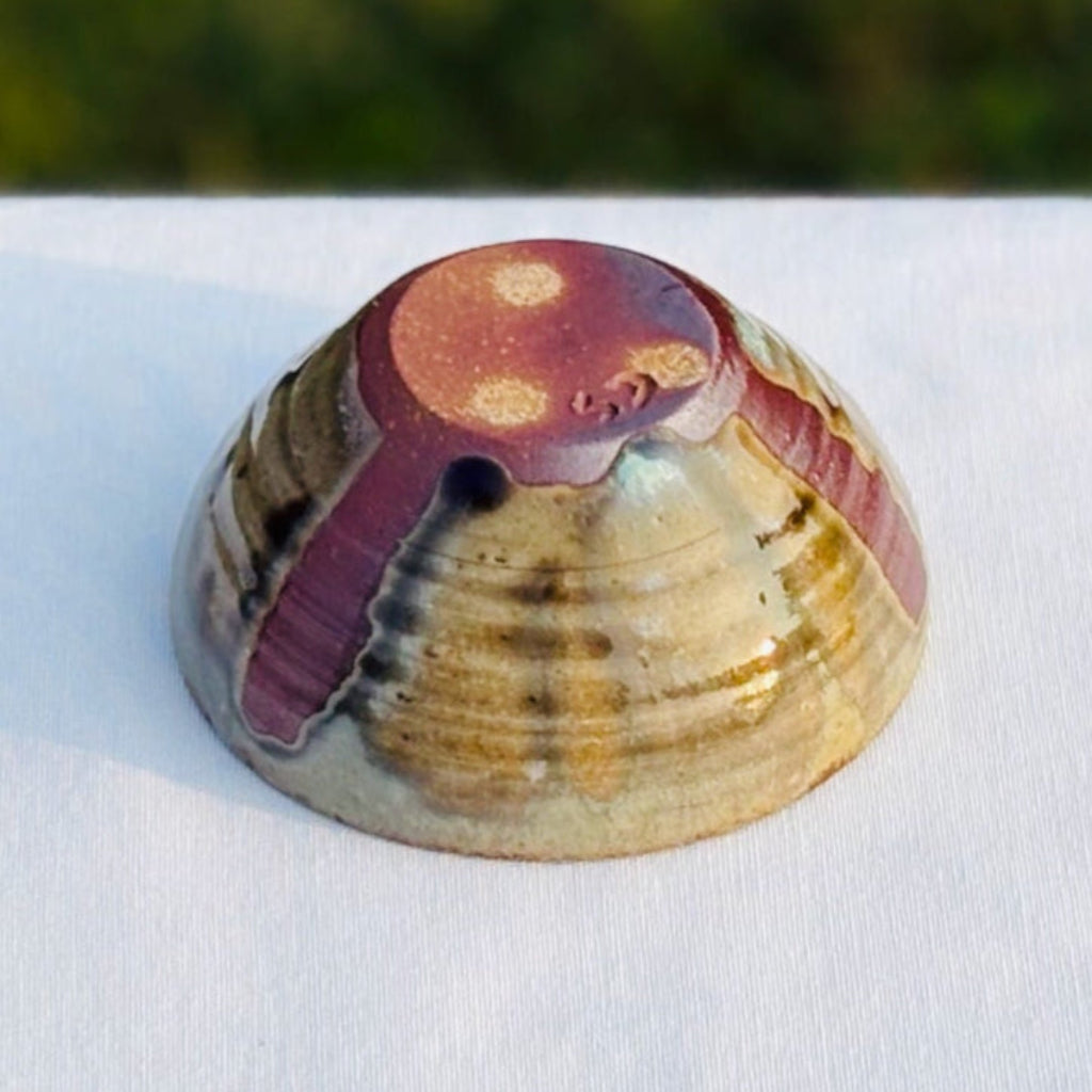 Wood-fired pottery ring dish with bold amber brown bottom with three dots and artist's mark