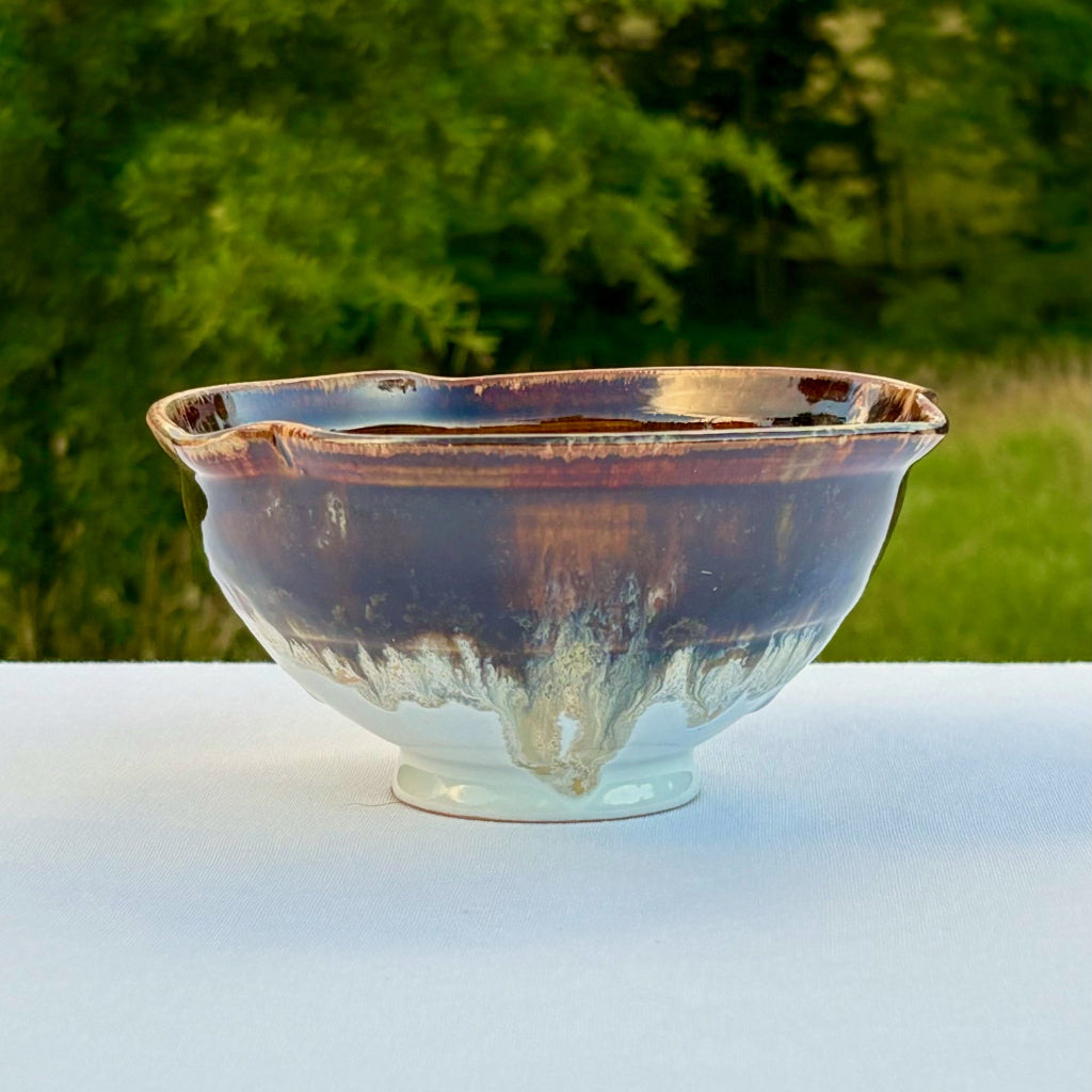 Three-lobed artisan ceramic bowl with variegated tenmoku glaze flowing to white base